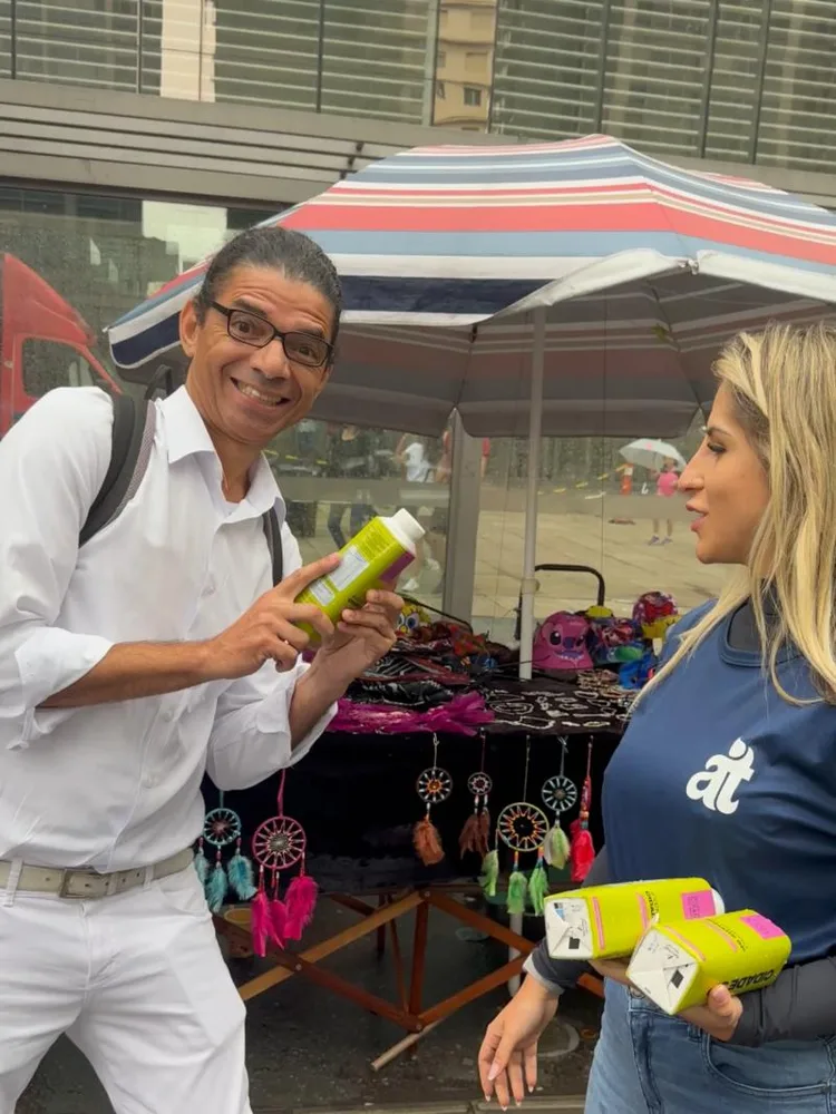 Promotora da Acqua.Tís entrega a caixinha amarela do Shopping Cidade São Paulo a um pedestre na Avenida Paulista