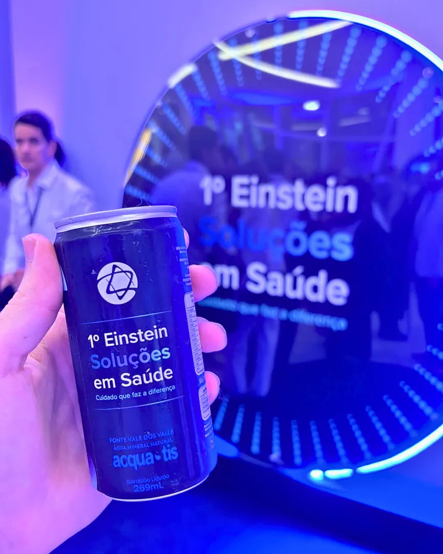 Lata azul personalizada do Einstein Soluções em Saúde na mão de uma participante do evento
