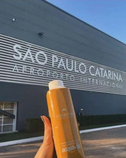 Caixinha Tetra Pak laranja personalizada do Aeroporto São Paulo Catarina, com o terminal ao fundo